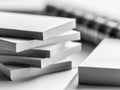Stacks of white paper sheets arranged with a blurred spiral notebook in the background for office or school supplies concept and Royalty Free Stock Photo