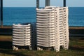 Stacks of white plastic chaise-lounge beach beds Royalty Free Stock Photo