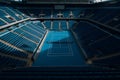 Stadium with blue hard tennis court and empty tribunes