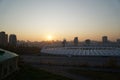 Stadium construction. Aerial view of the stadium roof on the city`s background. Sunset behind stadium for soccer Royalty Free Stock Photo