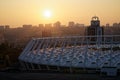 Stadium construction. Aerial view of the stadium roof on the city`s background. Sunset behind stadium for soccer Royalty Free Stock Photo