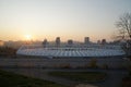 Stadium construction. Aerial view of the stadium roof on the city`s background. Sunset behind stadium for soccer Royalty Free Stock Photo