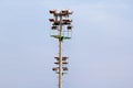 Stadium floodlight tower with reflectors with blue sky background