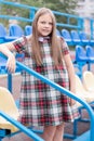 Stadium tribune. tweet brunette girl in dress near Tribunes and plastic colorful chairs in the sports stadium. Royalty Free Stock Photo