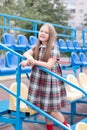 Stadium tribune. tweet brunette girl in dress near Tribunes and plastic colorful chairs in the sports stadium. Royalty Free Stock Photo