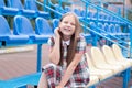 Stadium tribune. tweet brunette girl in dress near Tribunes and plastic colorful chairs in the sports stadium. Royalty Free Stock Photo