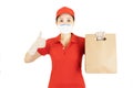 Staff,Asian Delivery in red uniform isolated on white background.Courier in protective mask and medical gloves,concept delivers