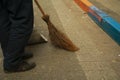 staff cleaning city street with broom tool