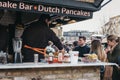 Staff cooking Dutch pancakes at a stall inside Camden Market, London, UK