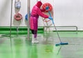 Staff hygien cleaner in protective uniform cleaning floor of food processing plant Royalty Free Stock Photo