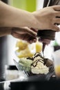 Staff making italian gelato ice cream sundae in modern shop