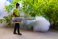 Staff member of Medhufushi Island Resort spraying garden in Maldives.