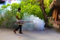 Staff member of Medhufushi Island Resort spraying garden in Maldives.