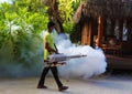 Staff member of Medhufushi Island Resort spraying garden in Maldives. Royalty Free Stock Photo