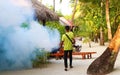 Staff member of Medhufushi Island Resort spraying garden in Maldives.