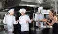 Staff of restaurant with nice chef in kitchen Royalty Free Stock Photo