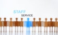 Staff service sign above line of toy human figures