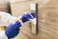 Staff using disinfectant from the bottle spraying an elevator push button control panel. Royalty Free Stock Photo