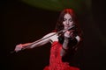 On stage - beautiful, frail and slender girl with fiery red hair - a well-known musician, virtuoso violinist Maria Bessonova. Royalty Free Stock Photo