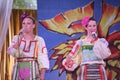 On the stage beautiful girls in national Russian costumes, gowns sundresses with vibrant embroidery - folk-music group the Wheel. Royalty Free Stock Photo