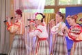 On the stage beautiful girls in national Russian costumes, gowns sundresses with vibrant embroidery - folk-music group the Wheel. Royalty Free Stock Photo