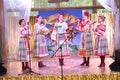 On the stage beautiful girls in national Russian costumes, gowns sundresses with vibrant embroidery - folk-music group the Wheel. Royalty Free Stock Photo