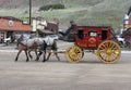 Stage Coach being pulled by Two Horses through Town