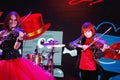 On stage, the expressive red-haired violinist Maria Bessonova sons twins. violin trio two generations of red fiery musicians. Royalty Free Stock Photo