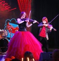 On stage, the expressive red-haired violinist Maria Bessonova sons twins. violin trio two generations of red fiery musicians. Royalty Free Stock Photo