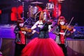 On stage, the expressive red-haired violinist Maria Bessonova sons twins. violin trio two generations of red fiery musicians. Royalty Free Stock Photo