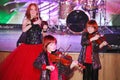 On stage, the expressive red-haired violinist Maria Bessonova sons twins. violin trio two generations of red fiery musicians. Royalty Free Stock Photo