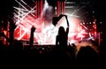 Stage lights against a happy woman with raised arms while enjoying a concert at a music festival Royalty Free Stock Photo