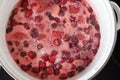 Stage of making homemade strawberry jam. Ripe berries boil with sugar in saucepan on hob. top view Royalty Free Stock Photo