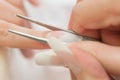 Stage of manicure: nail shaping by tweezers Royalty Free Stock Photo