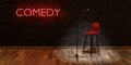 Stage with microphone and stool with red neon lamp with the word COMEDY. space for text