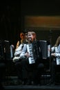 On stage, the musicians and soloists of Orchestra of accordionists (harmonic orchestra) under the baton of conductor. Royalty Free Stock Photo