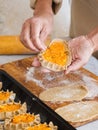 Stage of preparation of Karelian pies. Pies are located on a baking sheet, ready for baking. In the background, a woman is Royalty Free Stock Photo