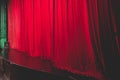 Stage with velvet red curtain in theater cinema, empty old-fashioned elegant theatre wooden stage with red cloth drapes curtains