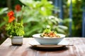 staged bun cha dish in an outdoor garden setting