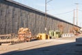 Staging area of road construction materials beside a concrete retaining wall and elevated highway Royalty Free Stock Photo