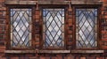 Stain glass with diamond pattern and brown rectangular wooden frames on grungy red brick wall front view. Abstract