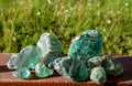 Stained glass from old glassworks smoothed and rounded in a mountain river collected by children beautifully stand out in the sun