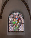 Stained glass window in an arched recess in the church of Saint Severus in Boppard, Germany Royalty Free Stock Photo