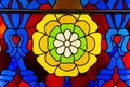 The stained glass window is bright and beautiful in the form of a yellow green blue flower. World tourism