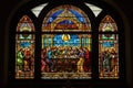 stained glass window depicting the last supper, with a view of individual pieces of mosaic art adorning the background Royalty Free Stock Photo