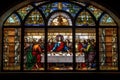 stained glass window depicting the last supper, with a view of individual pieces of mosaic art adorning the background Royalty Free Stock Photo