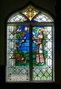 Stained glass window depicting St Frances with birds.