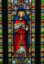Stained glass window depiction of Jesus holding cross bearing orb. Royalty Free Stock Photo