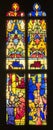 stained glass window with icons and medieval religious scenes