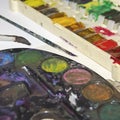 Stained paint palette with brushes near